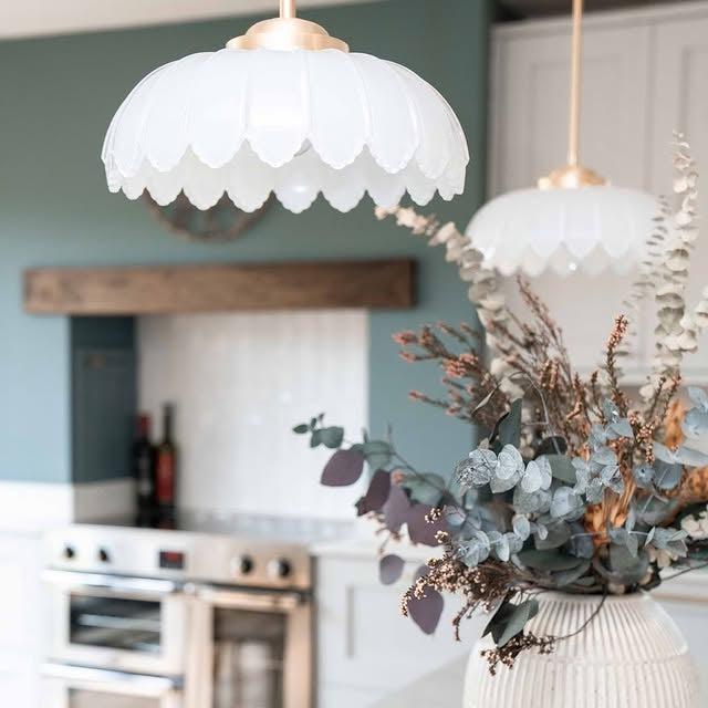 Decorative lampshades and a vase with flowers on a kitchen counter.