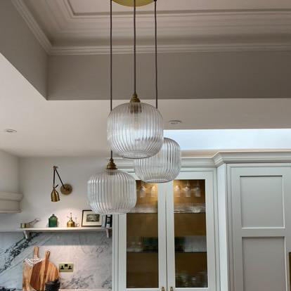 Modern kitchen with marble countertops and reeded pendant lights